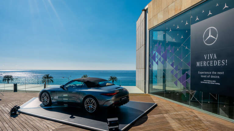 Convertible Mercedes-Benz displayed on a terrace overlooking the Mediterranean Sea.